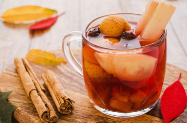 a cup of ponche de navidad made from a variety of fruits for nochebuena